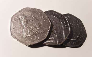 Three fifty pence coins on white.
