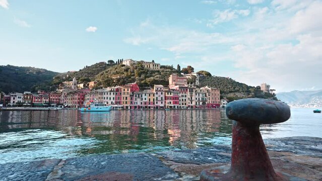 View from behind rusted bollard at harbor of Portofino seaside vilage, Italy