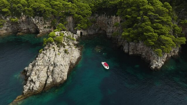 Adriatic Sea, Croatia - A Sailboat Drifting Near the Steep, Rugged Cliffs of Kalamota Island - Aerial Ascend Pullback
