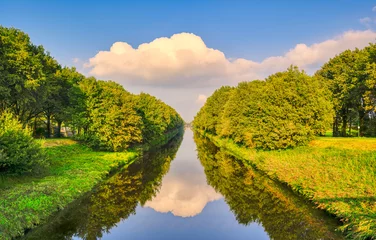Foto auf Leinwand Reflection of clouds on the Wilhelminakanaal canal near the village of Aarle-Rixtel, The Netherlands. © Alex de Haas