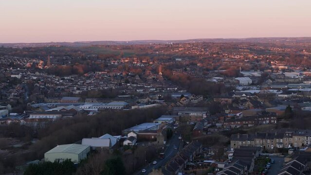 Aerial video footage of industrial buildings and housing. Terraced streets in textile towns at sunset. Chemical Plant surrounded by red brick homes with busy streets. Yorkshire living concept