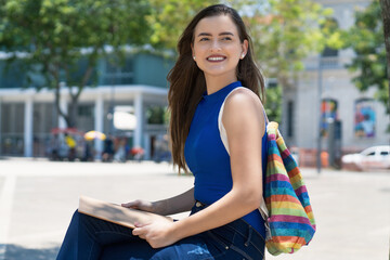 Young caucasian female student with brunette hair and colorful backpack