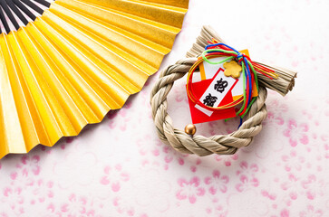 金色の扇と正月飾りとピンク色の和紙の和風イメージ