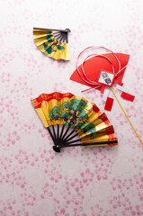 扇と正月飾りとピンク色の和紙の和風イメージ