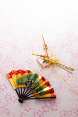 扇と正月飾りとピンク色の和紙の和風イメージ
