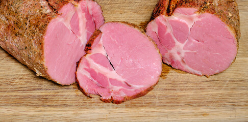 thin slice of juicy homemade ham on an oak cutting board
