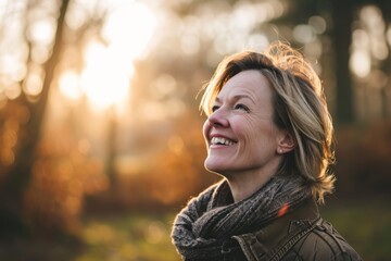 Portrait of smiling senior woman in the forest at sunset. Focus on face.