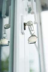Landlord key for unlocking house is plugged into the door. Second hand house for rent and sale. keychain is blowing in the wind. mortgage for new home, buy, sell, renovate, investment, owner, estate