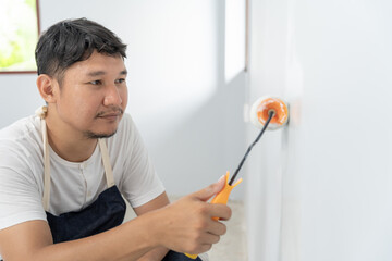painter man, brush in hand for products to restore and paint the wall, indoor the building site of...