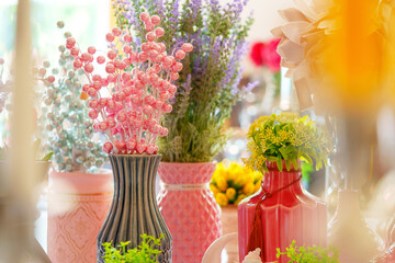 Vibrant Bouquets in Eclectic Vases on a Sunlit Table at a Springtime Event