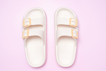 Rubber summer flip-flops on pink background close-up, top view.