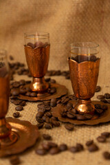 copper cups and coffee beans placed on a sack material background