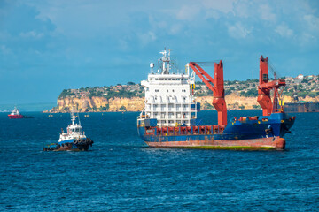 Busy container ship and tug boat traffic in the port of Luanda, Angola, Central Africa