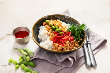  Vegan food. Soy meat, white rice, beans, red pepper on light wooden background © bit24