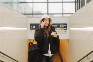 Tourist teenage girl at train station using smartphone map, social media check-in, or buy ticket booking. Modern travel app technology, lone traveler, Winter vacation railroad adventure concept