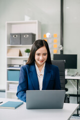 Confident Asian woman with a smile standing holding notepad and tablet at office..