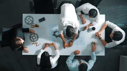 Top down aerial view of smart engineer team working together to design turbine engine. Professional...