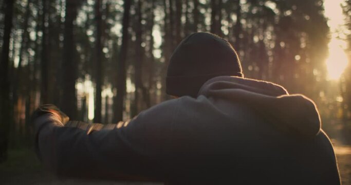 Portrait of young man athlete training in the forest. Shadow boxing on sunrise in nature