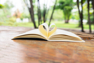 Open book with pages forming heart shape.background