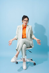 Photo of young Asian businesswoman on blue background