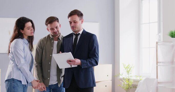 Young family couple in the process of choosing and buying a new house meeting with a real estate agent, exchanging handshakes, and discussing a contract agreement