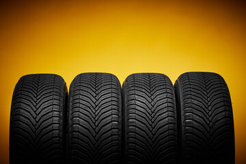 Car tires, winter wheels isolated on yellow background and screwdriver - obrazy, fototapety, plakaty