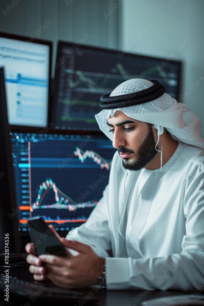 Wall mural  An Arab businessman sitting in front of an open data analysis graph in computer screen and using his smartphone Fictional Character Created by Generative AI. - Wall murals