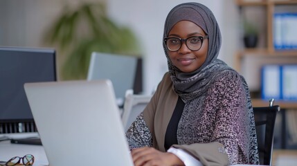 An African Muslim businesswoman wearing a hijab, sitting at a table and working on her laptop. Fictional Character Created by Generative AI.
