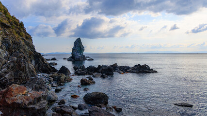 Sacred Kamitate Gamiiwa coastal rock formation with calm sea and horizon on cloudy morning