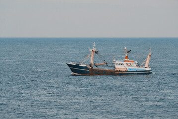 Naklejka premium Boat At Sea Engaged In Fishing Operation