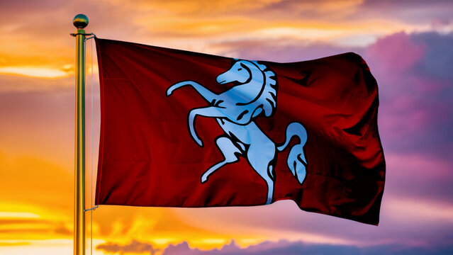 Kent Waving Flag Against a Cloudy Sky at Sunset.