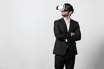 Smart business man crossing arms and standing with folded arm at white background. Professional manager looking at financial graph by using technology innovation to visit enter metaverse. Deviation.