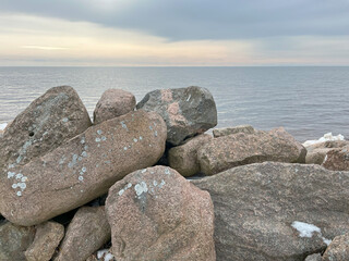 Large stones lie on the seashore. Stone ridge.
