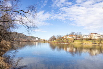 walking along nidelven (river) in a spring mood in trondheim city, trøndelag, nidelven, water, river, landscape, sky, nature, city, reflection, view, trees, clouds, travel, architecture, house, buildi - 782892188