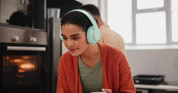 Girl, headphones and vlogging on laptop in kitchen with laughing, video upload and social media post. Food blog, gen z influencer couple and content creation with funny meal ideas and recipe in home