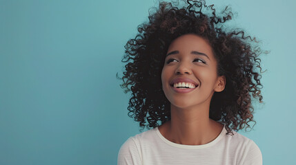 Happy Dark Skinned Woman with curly hair standing. Isolated on pastel blue background