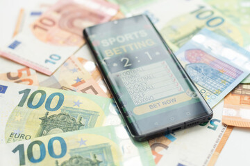 Smartphone with gambling mobile application with money close-up. Sport and betting concept