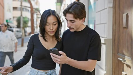 A young interracial couple engrossed in a smartphone on a bustling city street. - Powered by Adobe