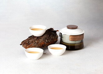 Asian tea set with a teapot and cups on white background woth wood decoration