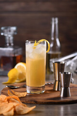 Whiskey cocktail with ginger beer, garnished with lemon 