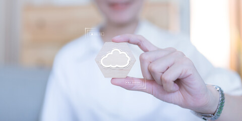 A woman's arm holds a wooden block with a cloud icon symbol. Digital technology data storage concept