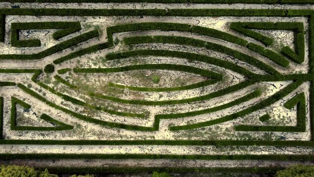 Aerial top view of a green labyrinth garden in Ames, Spain