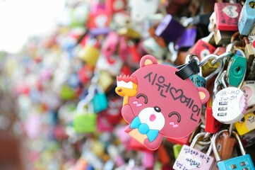 Closeup shot of a cute toy hanging on a wall full of promise locks