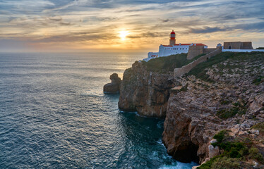 moody view on Cabo Sao Vicente with its famous lighthouse at sunset at the south.estern spit of...