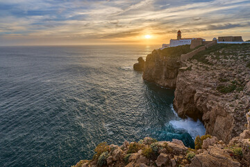 moody view on Cabo Sao Vicente with its famous lighthouse at sunset at the south.estern spit of...