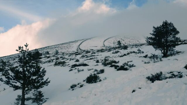 Navacerrada, Madrid, Spain. Clouds drifting over the snowy peak of the Navacerrada ski resort.