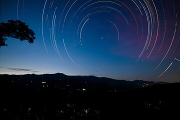 Beautiful view of the night sky with star trails. - obrazy, fototapety, plakaty