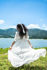 Back view of Sri Lankan woman posing in white dress in the open air