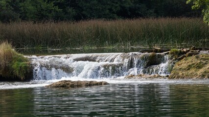 Fototapeta na wymiar Scenic view of a river flowing through rocks in a green forest in Croatia