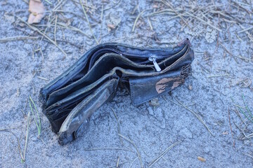 one empty black leather wallet lies on the gray ground on the street